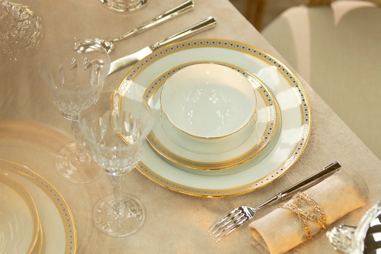 Table dressée avec assiettes en porcelaine à filet d'or