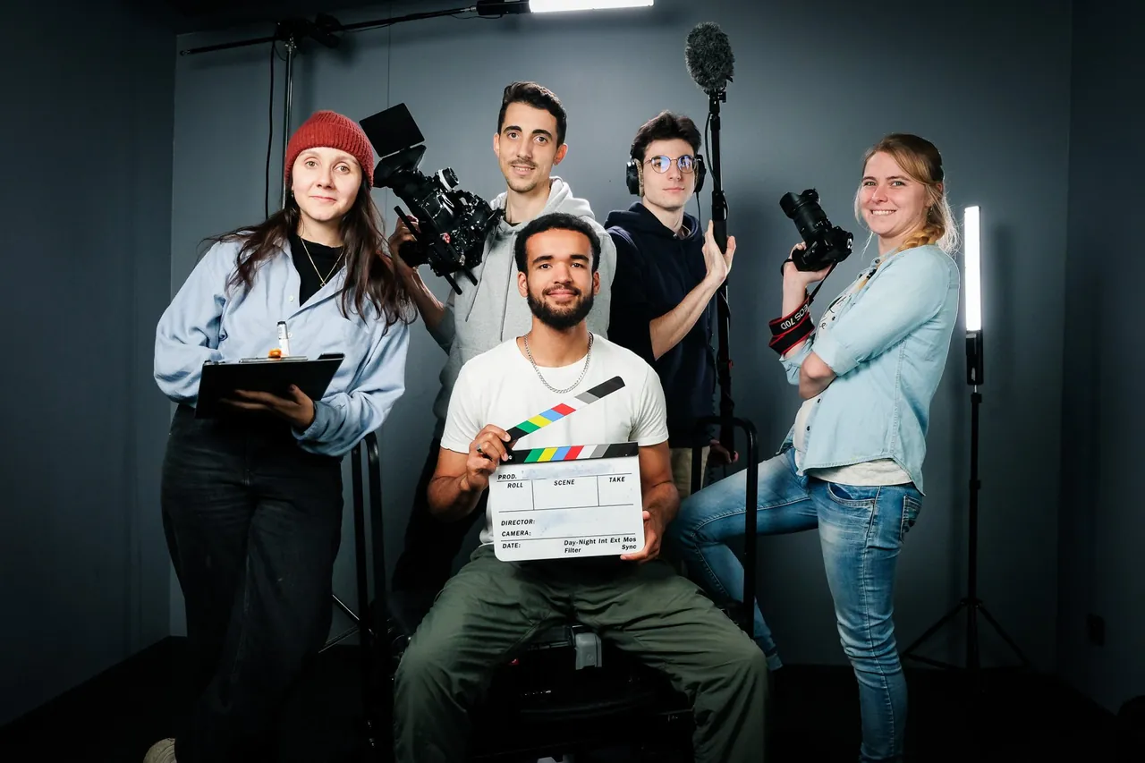 Équipe de tournage réunie en studio avec un clap