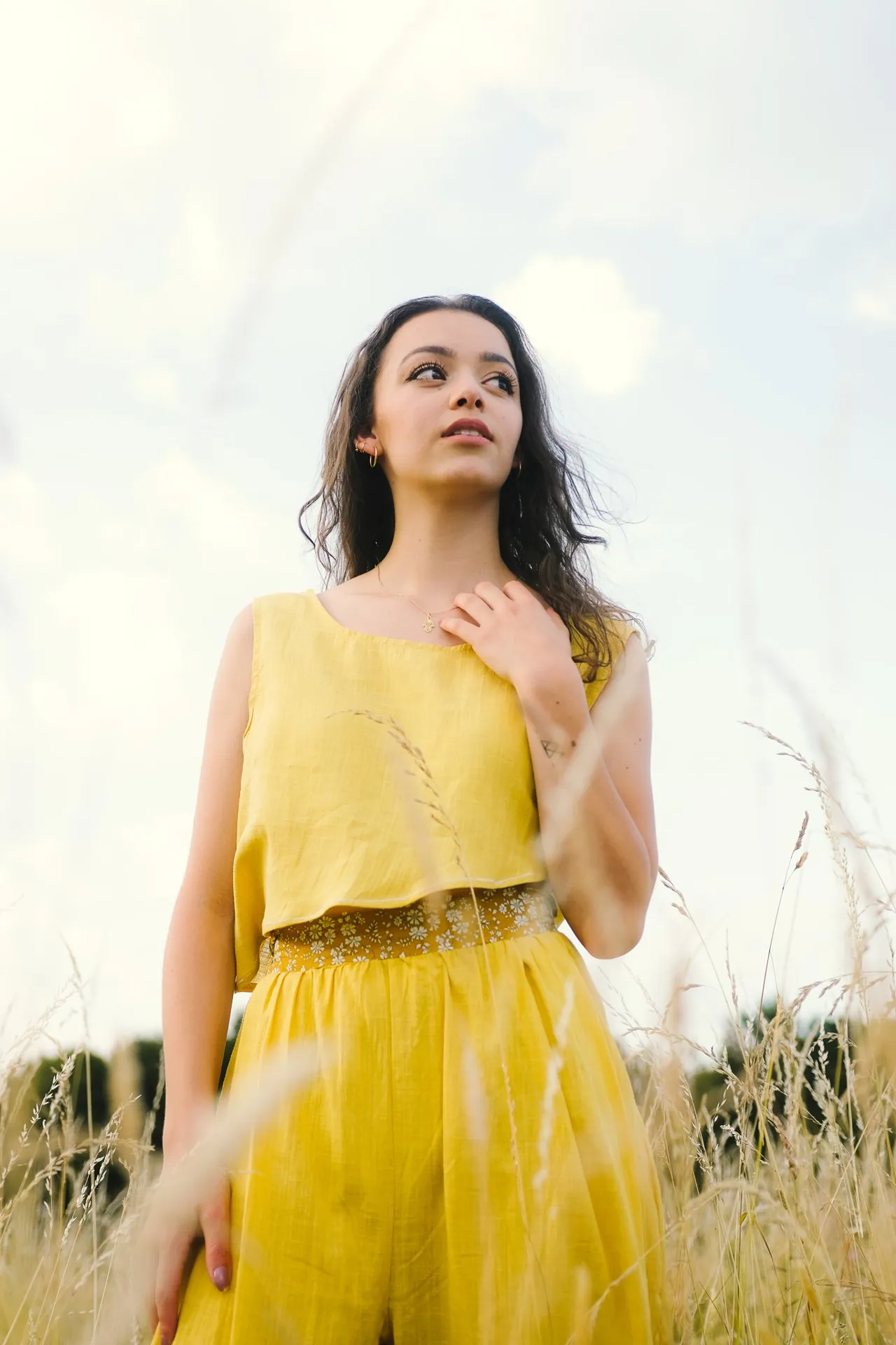 Femme en robe jaune dans un champ, lumière naturelle