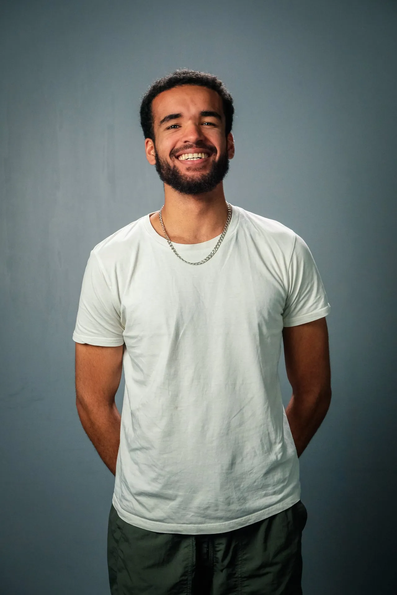Portrait studio d'un jeune homme souriant sur fond gris