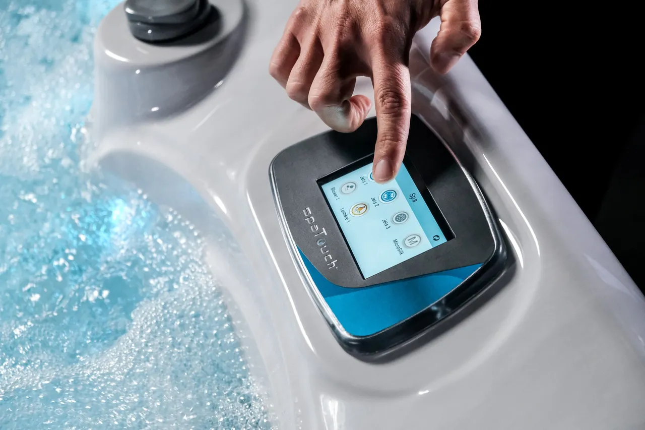 Main réglant le panneau de commande d'un spa