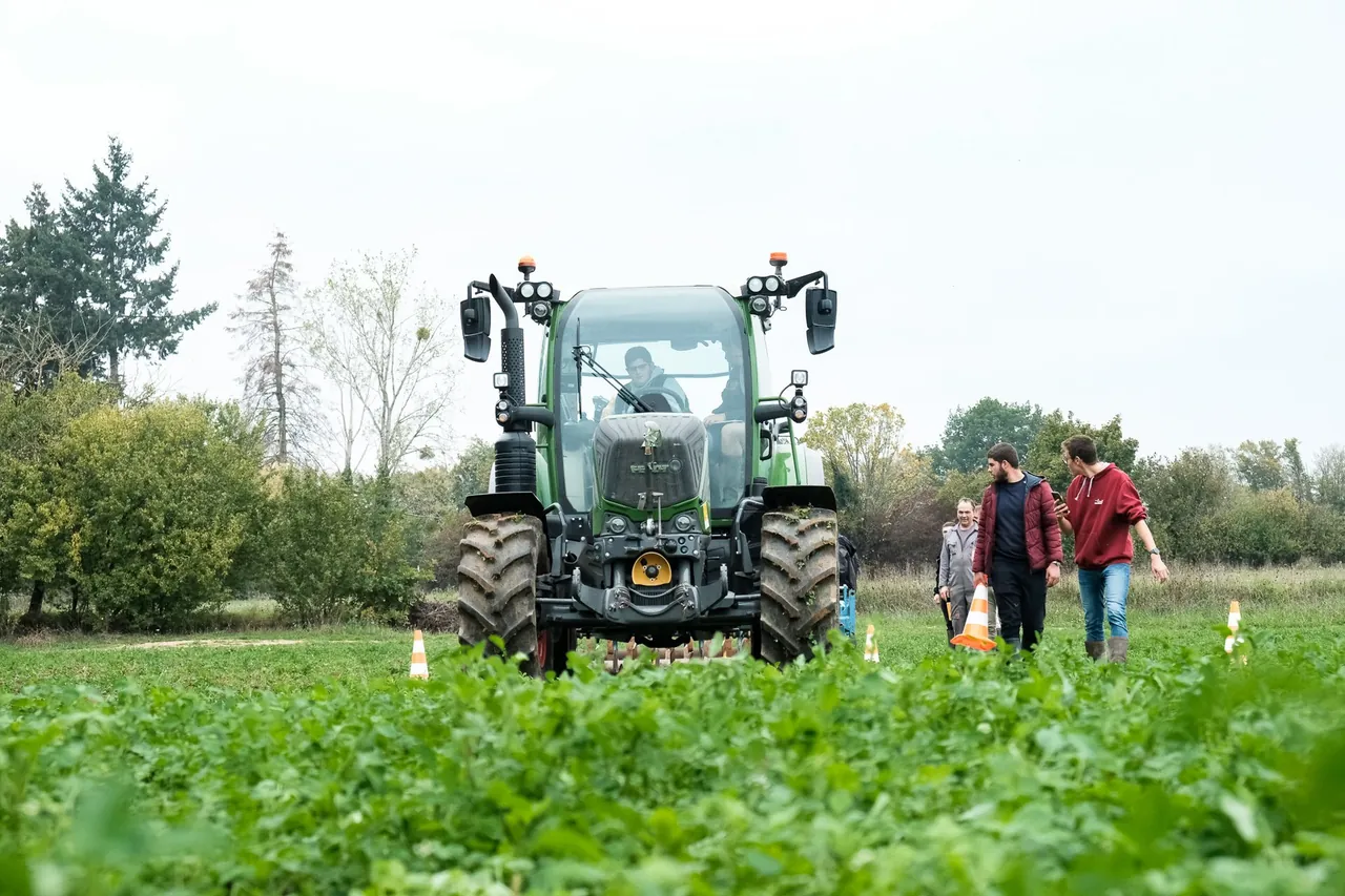 Visite d'un champ avec un tracteur et un groupe de personnes